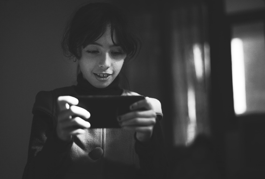 Black and white shot of a child using a mobile phone